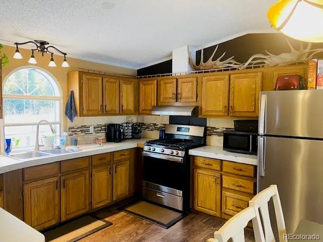 a kitchen with stainless steel appliances a stove a sink and a refrigerator