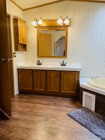 a bathroom with a double vanity sink a mirror and a toilet