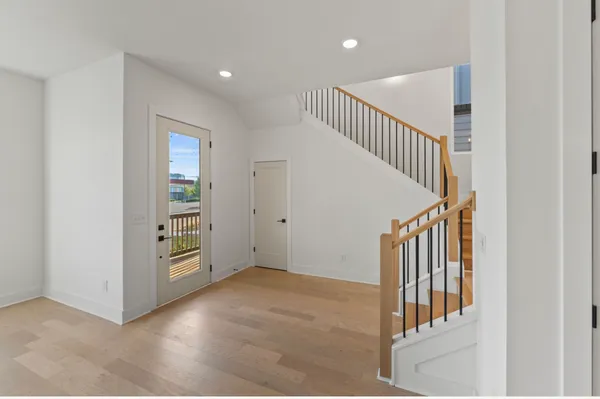 a view of a hallway with entryway and stairs