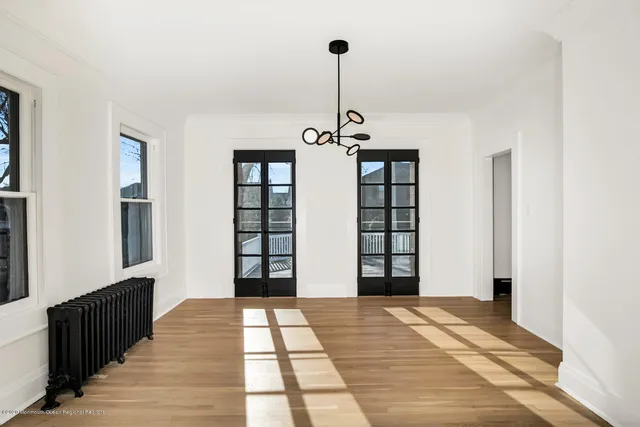 a view of a hallway with windows and chandelier