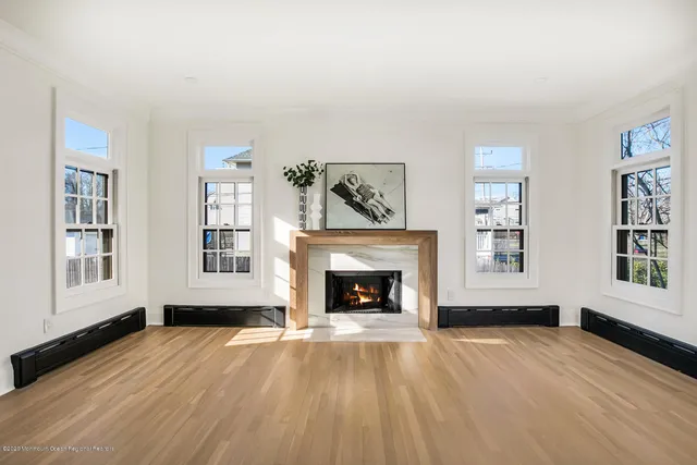 wooden floor fireplace and windows in an empty room
