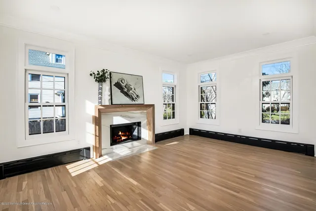 a view of an empty room with window and fire place