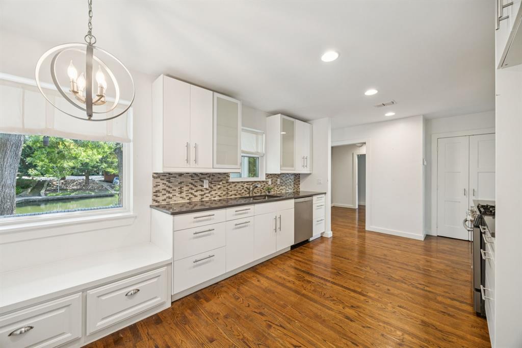 6742 Williamson Road Dallas, TX 75214 - Photo 7 of 11 BREAKFAST Area Features Custom L-Shaped Banquette Seating With Storage Drawers, Oversized Picture Frame Window Overlooking Backyard & Creek, Decorative Lighting, and Window Coverings