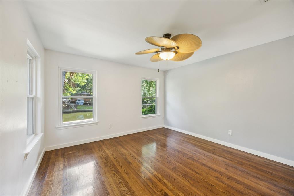 6742 Williamson Road Dallas, TX 75214 - Photo 8 of 11 PRIMARY at REAR of Home Features Multiple Windows With Views of the Backyard and Creek, Abundance of Natural Light, Decorative Celing Fan With Light Kit, Neutral Colors and Wood Flooring
