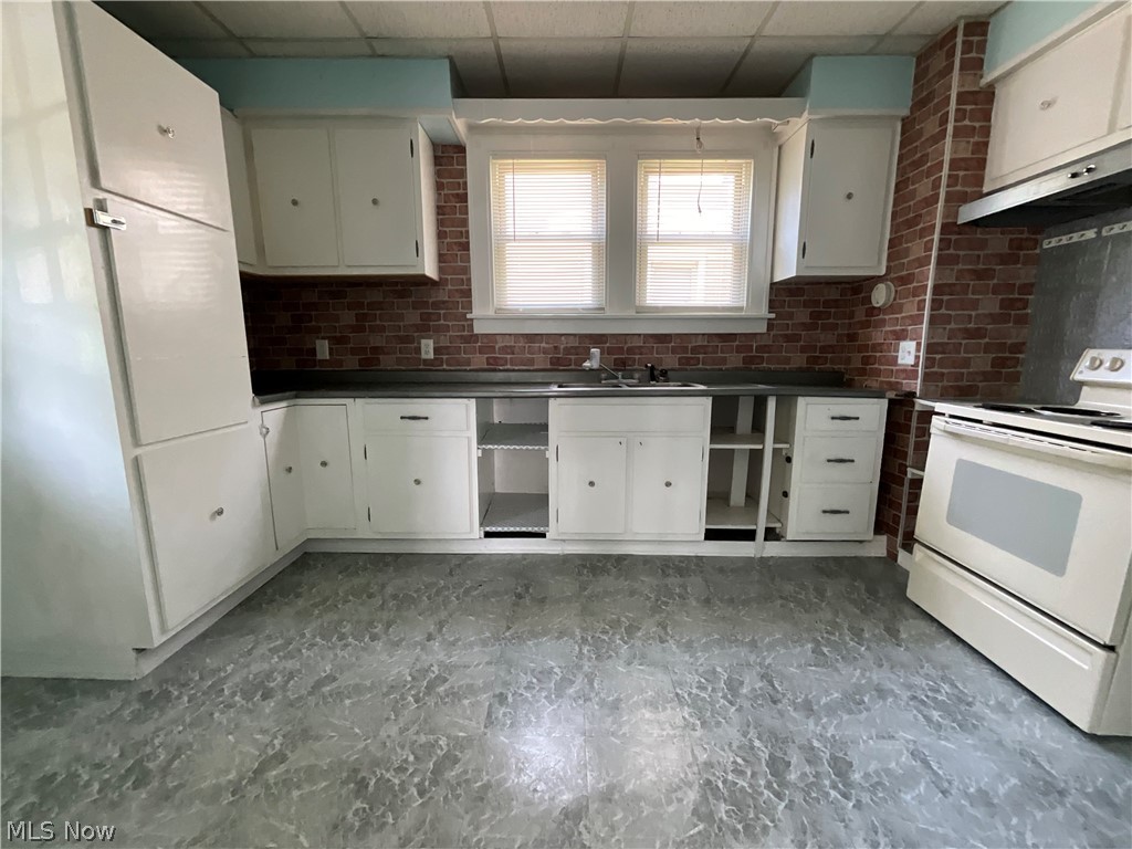700 Cove Road Weirton, WV 26062 - Photo 5 of 26 Kitchen with sink, white cabinetry, white electric stove, and a drop ceiling