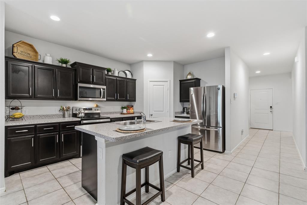 3400 Quiet Valley Road Fort Worth, TX 76123 - Photo 13 of 31 a kitchen with stainless steel appliances a stove refrigerator sink and microwave
