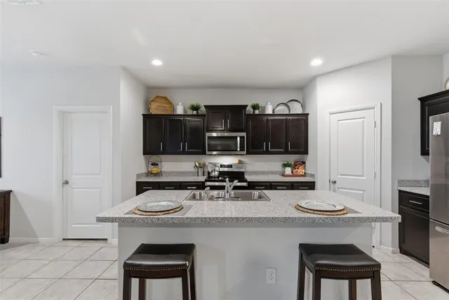 a kitchen with stainless steel appliances a stove refrigerator sink and microwave
