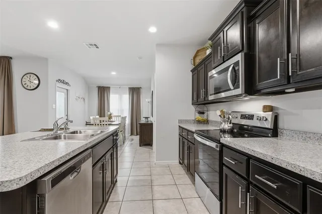 a kitchen with stainless steel appliances a sink stove and refrigerator