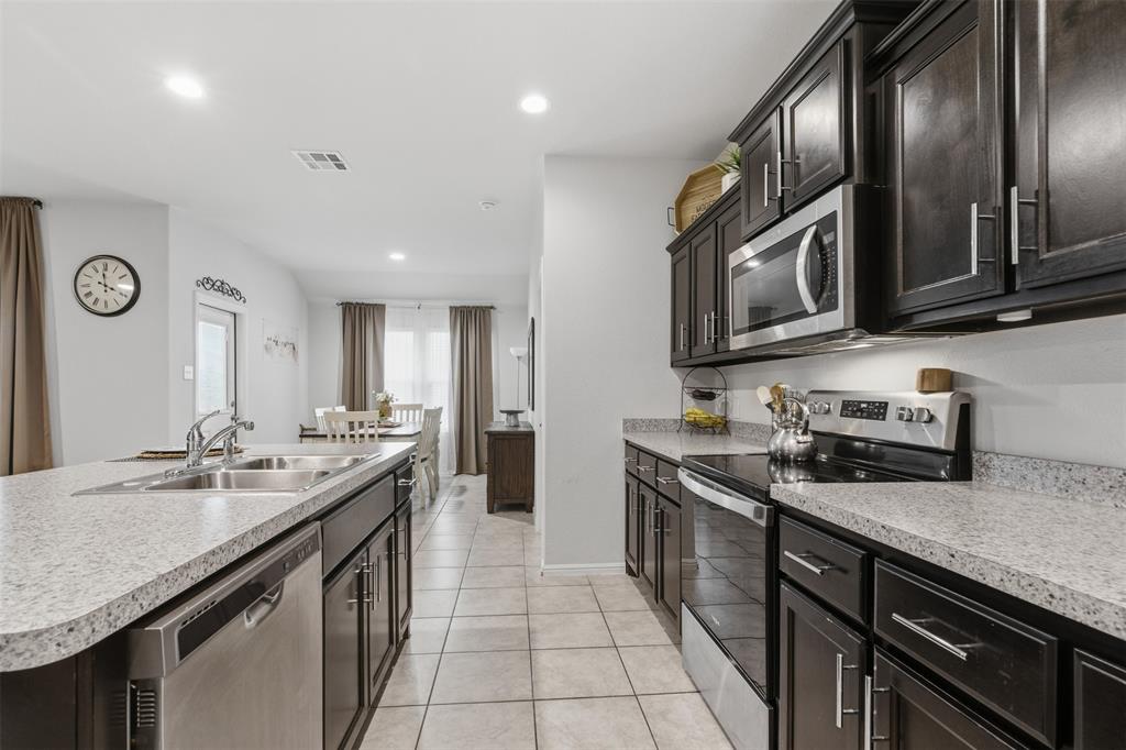 3400 Quiet Valley Road Fort Worth, TX 76123 - Photo 15 of 31 a kitchen with stainless steel appliances granite countertop a sink a stove oven and cabinets