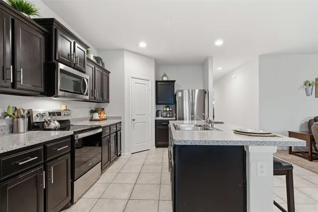 a kitchen with stainless steel appliances granite countertop a sink a stove oven and cabinets