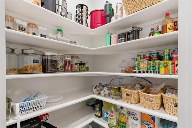 a kitchen with kitchen island granite countertop a sink dishwasher stove and refrigerator with wooden cabinets