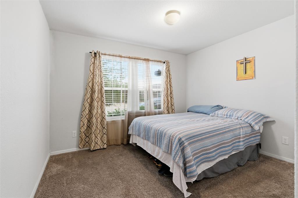 3400 Quiet Valley Road Fort Worth, TX 76123 - Photo 20 of 31 a bed sitting in a bedroom next to a window