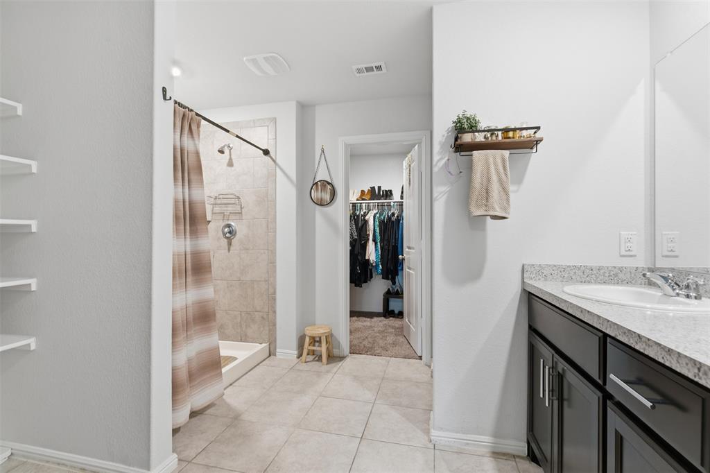 3400 Quiet Valley Road Fort Worth, TX 76123 - Photo 8 of 31 a bathroom with a granite countertop sink a mirror and a shower