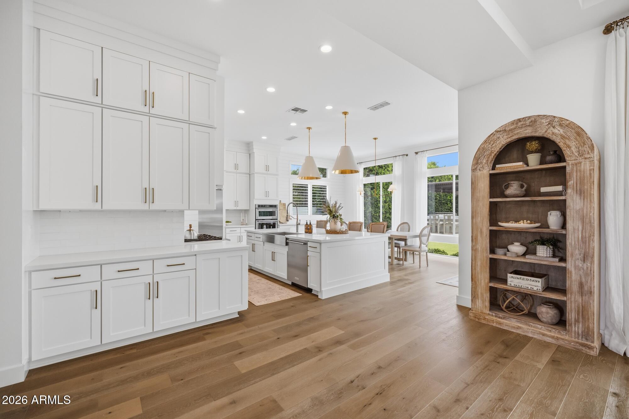 2633 East Geronimo Street Gilbert, AZ 85295 - Photo 14 of 78 a large white kitchen with stainless steel appliances and white cabinets