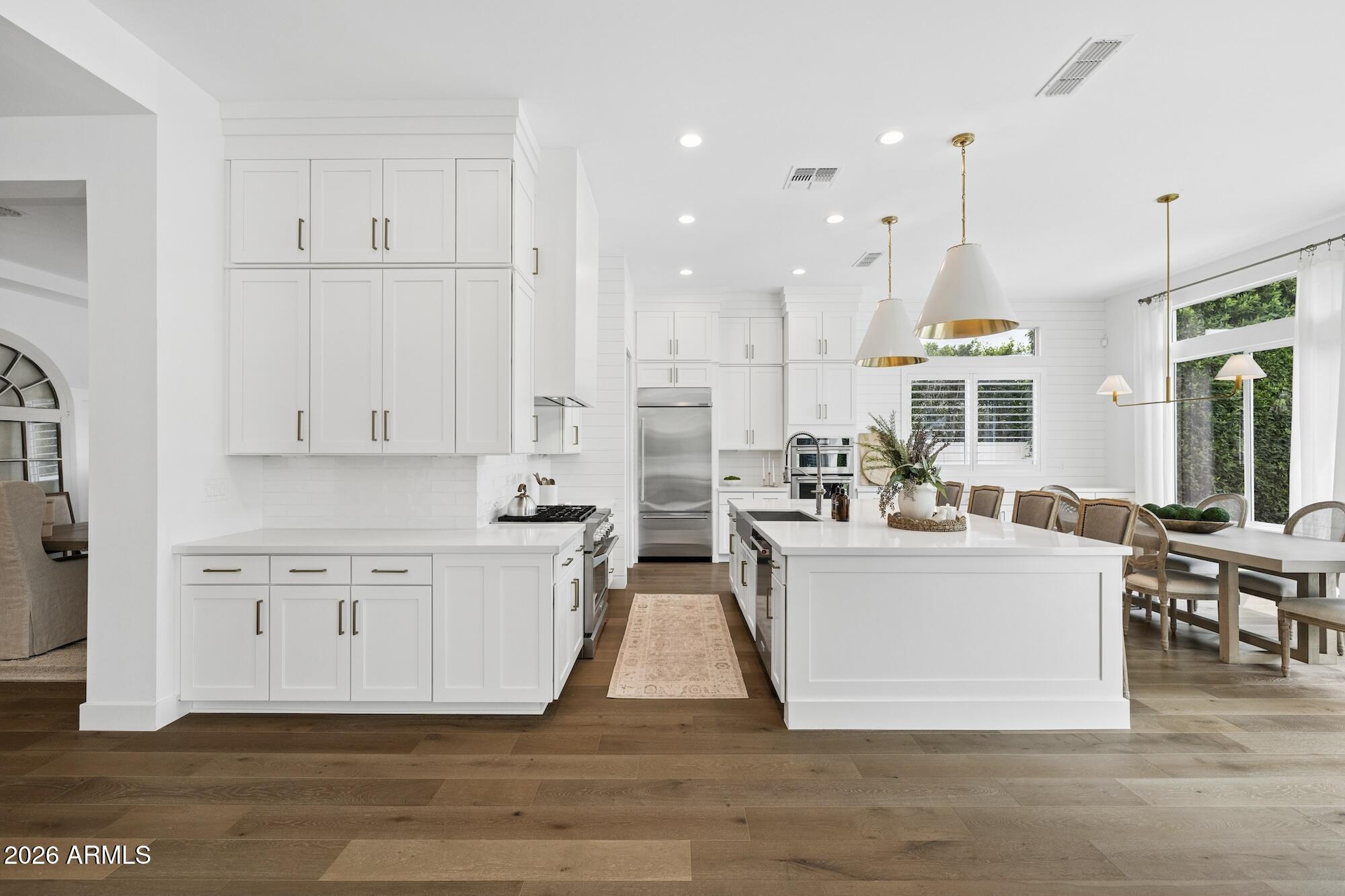 2633 East Geronimo Street Gilbert, AZ 85295 - Photo 15 of 78 a living room with stainless steel appliances kitchen island granite countertop a stove a sink a refrigerator and white cabinets with wooden floor