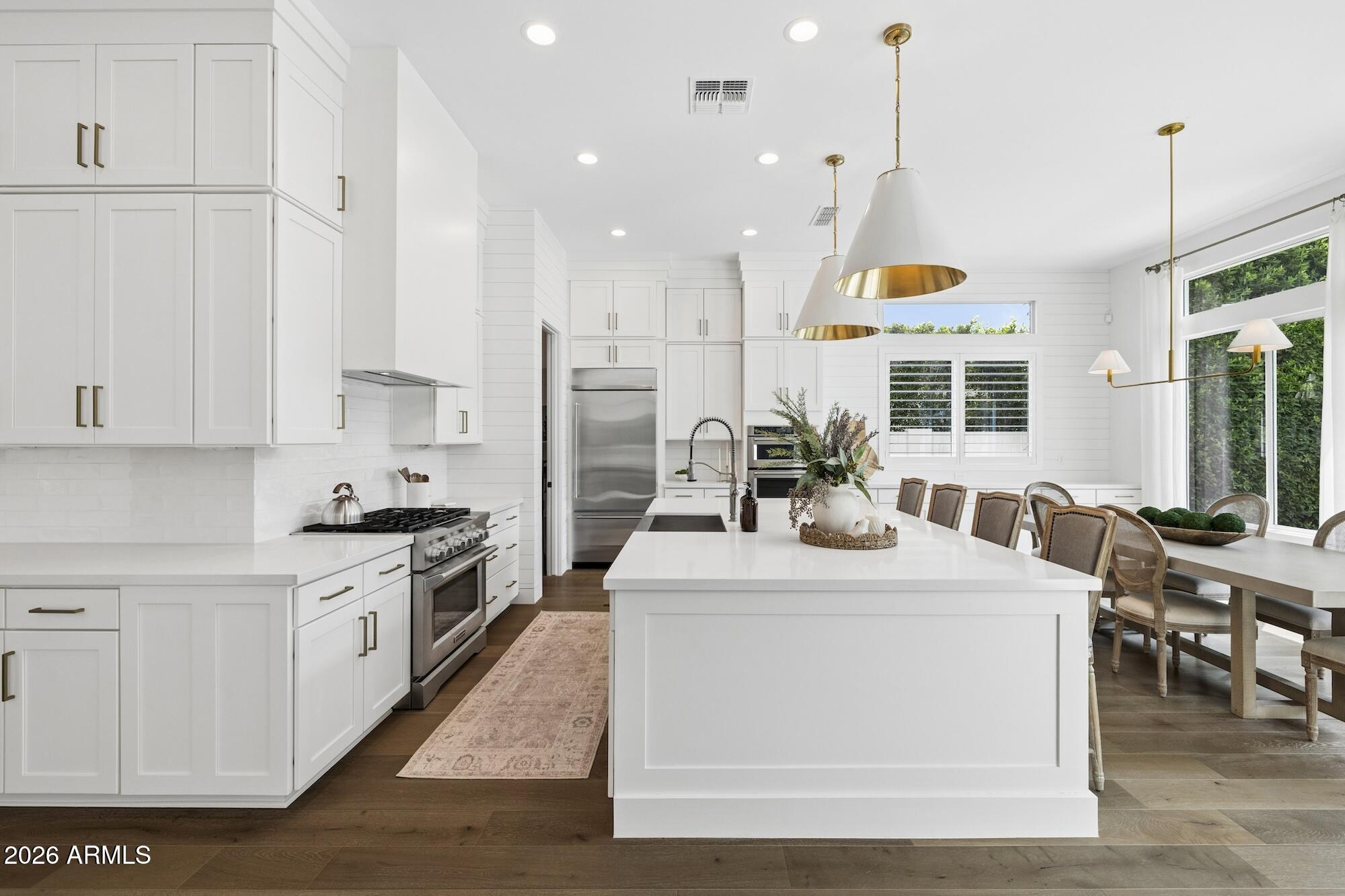 2633 East Geronimo Street Gilbert, AZ 85295 - Photo 16 of 78 a kitchen with stainless steel appliances kitchen island granite countertop a stove a sink a refrigerator and white cabinets with wooden floor