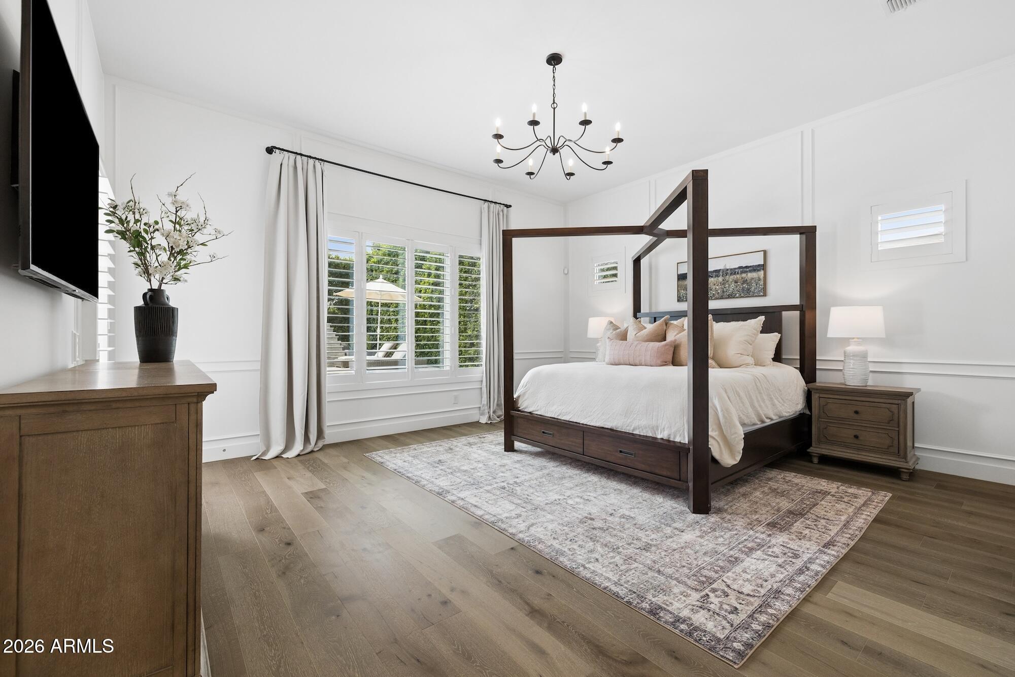 2633 East Geronimo Street Gilbert, AZ 85295 - Photo 49 of 78 a bedroom with a bed wooden floor and flat screen tv