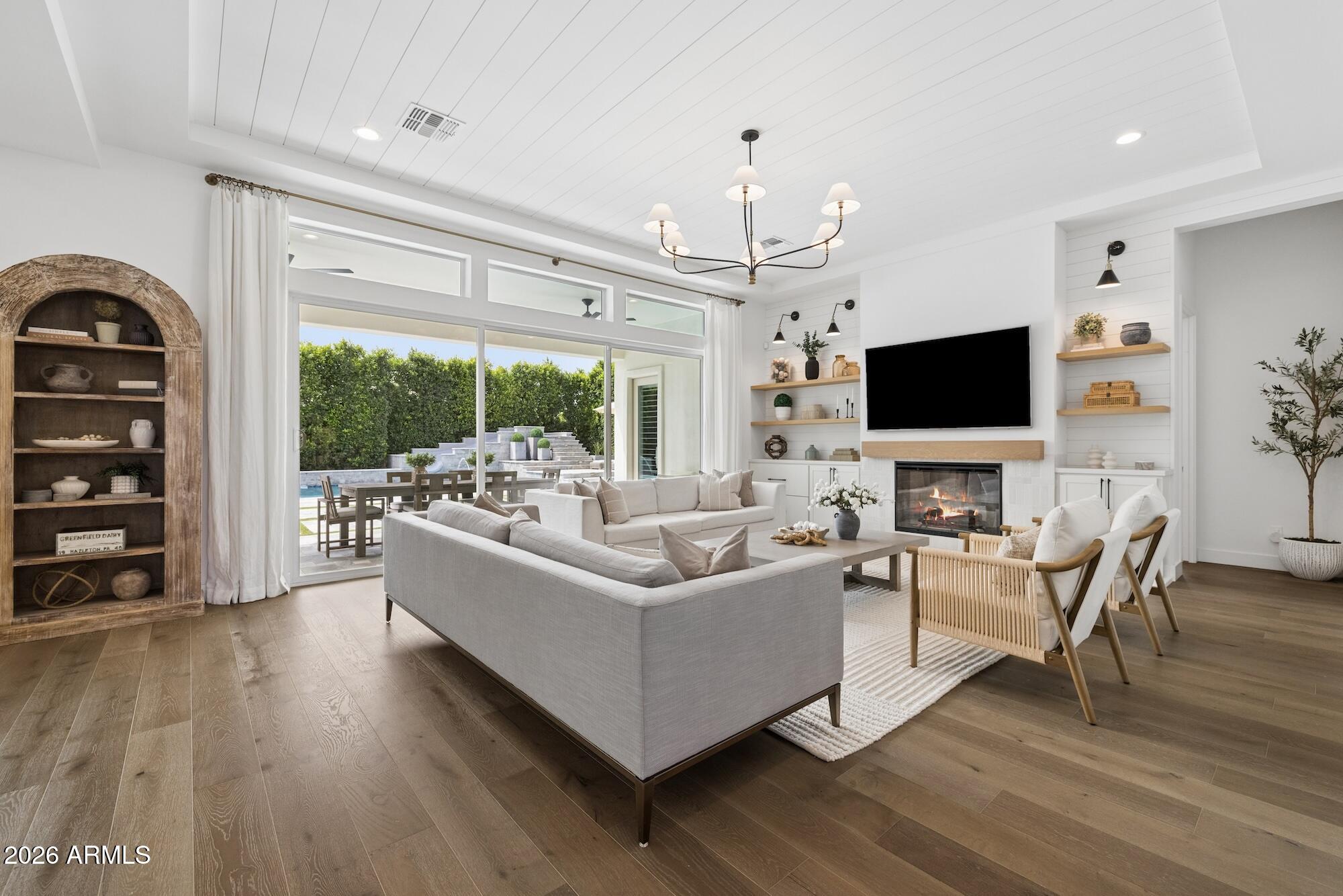 2633 East Geronimo Street Gilbert, AZ 85295 - Photo 8 of 78 a living room with furniture a flat screen tv and a floor to ceiling window