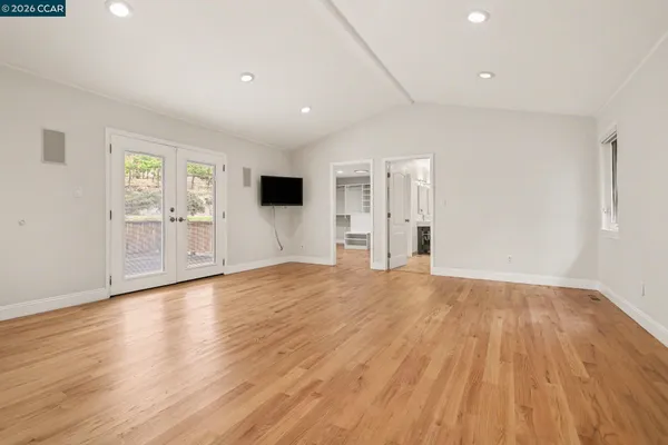 a view of empty room with wooden floor and window