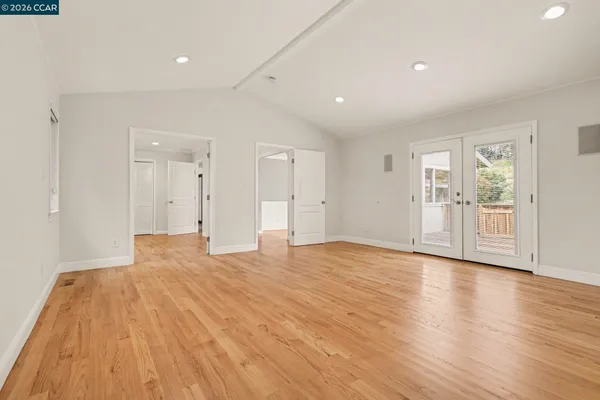 a view of empty room with wooden floor and windows