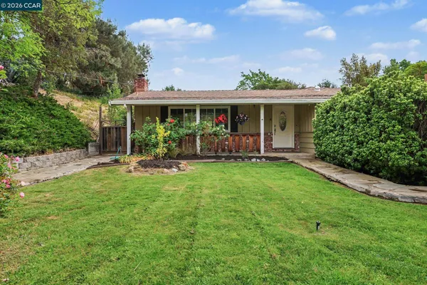 a view of a house with a yard and potted plants