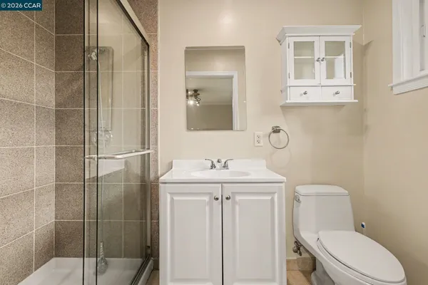 a bathroom with a granite countertop sink a toilet and a mirror