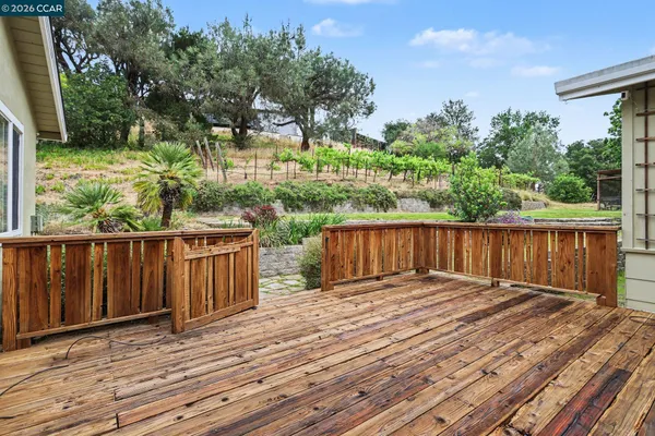 a view of balcony with wooden floor and fence