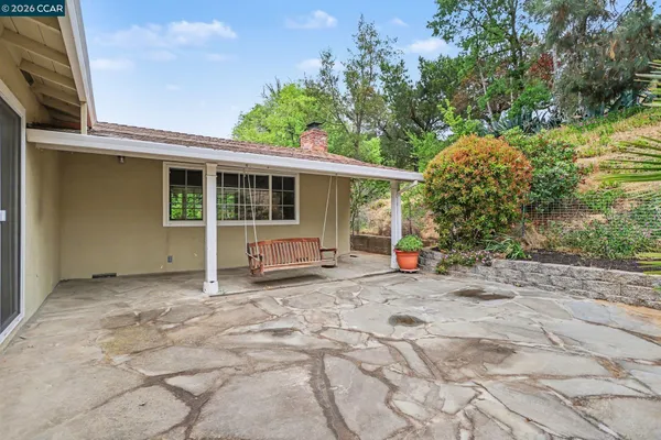 a view of a house with backyard and sitting area