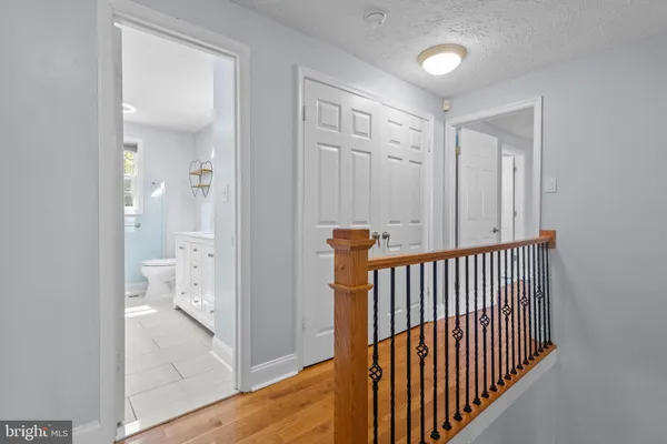 a view of hallway with bathroom and wooden floor