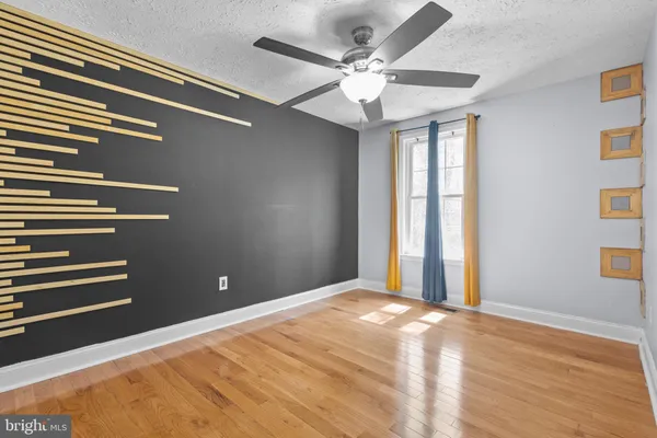 a view of a big room with wooden floor and windows
