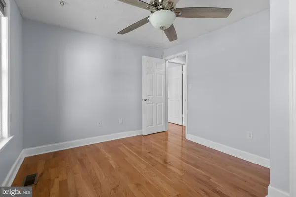 an empty room with a window and a ceiling fan