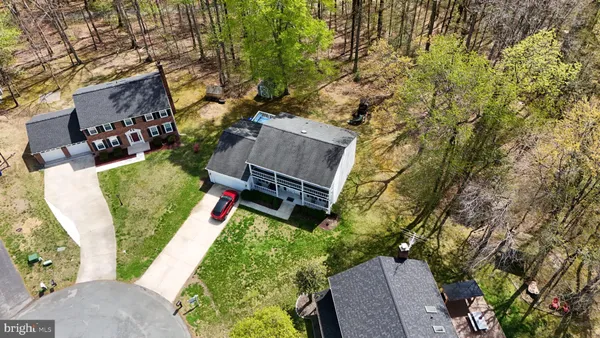 an aerial view of residential house with outdoor space and trees all around