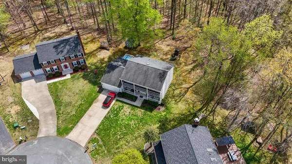 a aerial view of a house next to a big yard and large trees
