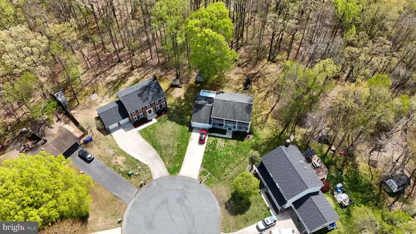 a aerial view of a house next to a big yard and large trees