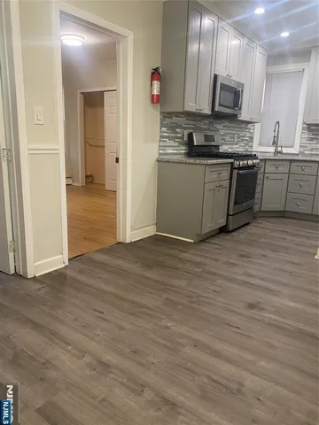 a kitchen with stainless steel appliances granite countertop a stove top oven sink and cabinets