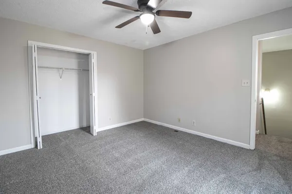 a view of an empty room and chandelier fan