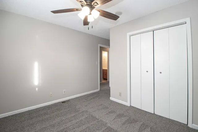 an empty room with a ceiling fan and a window