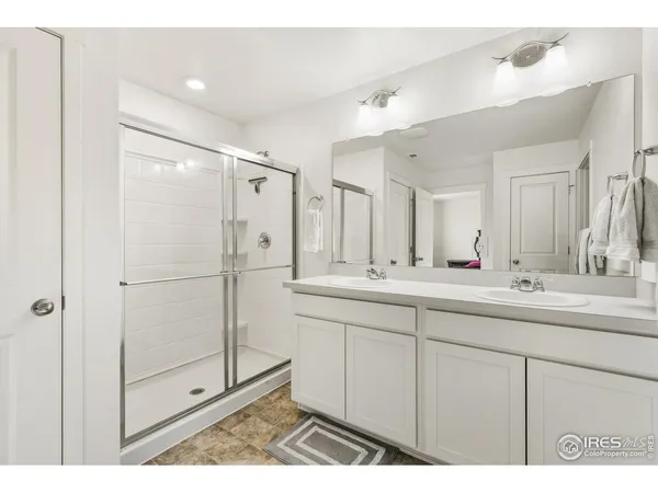 a bathroom with a double vanity sink mirror and shower
