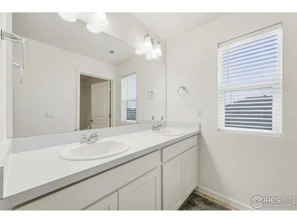 a bathroom with a sink double vanity granite and a mirror