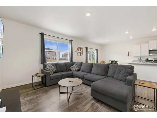 a living room with furniture and a view of kitchen