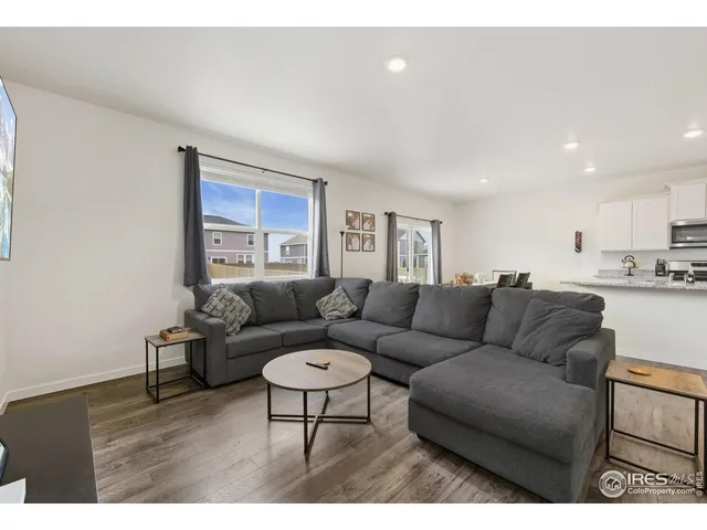 a living room with furniture and a view of kitchen