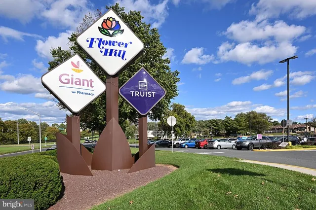 a view of a street with parking and sign board