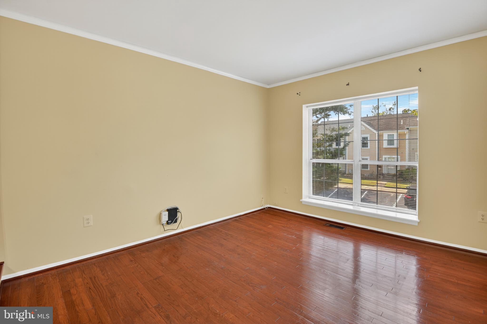 18314 Hallmark Court Gaithersburg, MD 20879 - Photo 5 of 26 an empty room with wooden floor and windows