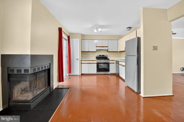 a kitchen with stainless steel appliances a stove a refrigerator and a fireplace