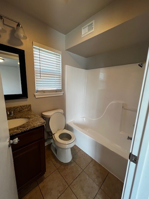 1172 Webberville Road, Unit 204 Austin, TX 78721 - Photo 5 of 10 Full bath with vanity, dark tile patterned floors, and shower / bath combination