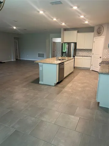 a large kitchen with a large counter top appliances and cabinets