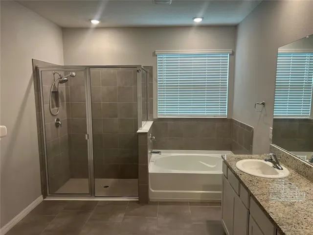 a bathroom with a granite countertop sink and shower