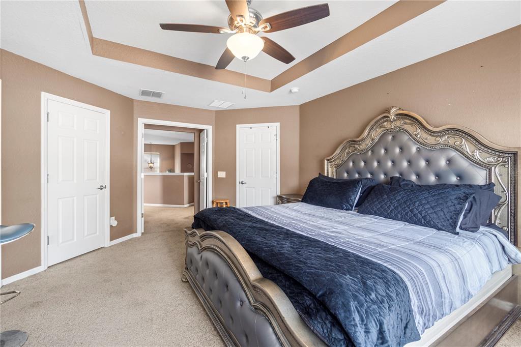 4199 Southwest 46th Court Ocala, FL 34474 - Photo 26 of 50 a bedroom with a large bed and a chandelier