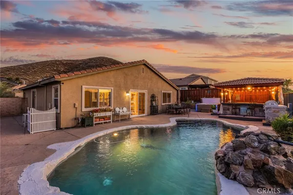 a view of a house with swimming pool and sitting area