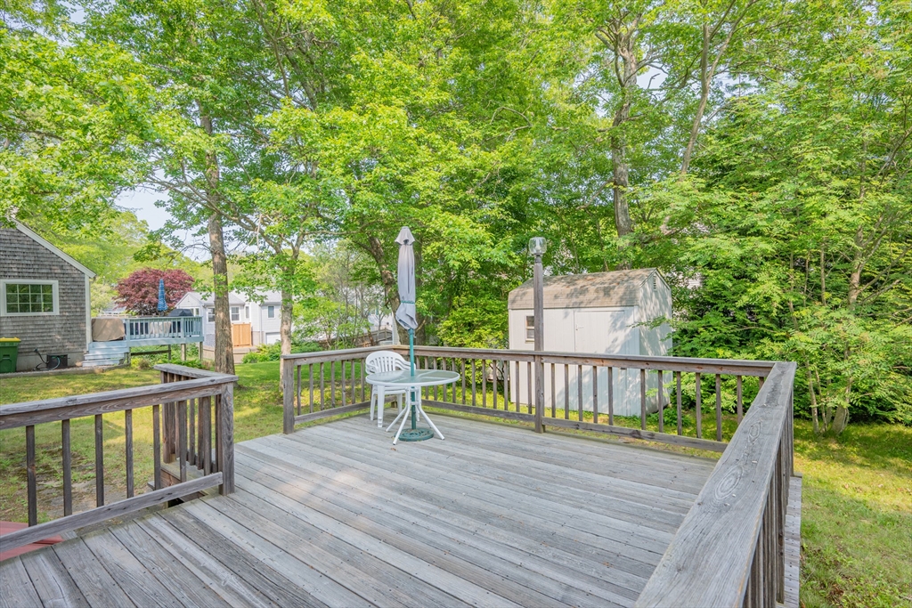 64 Uncle Percy's Road Mashpee, MA 02649 - Photo 23 of 33 a view of a deck with two chair and wooden floor